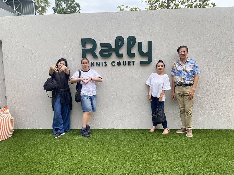 Guests at the Rally Tennis Court sign